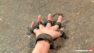 Lesbian strapped by metal to the ground