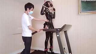 Mz24 - a Girl Bound to a Treadmill with Metal Restraints and Shackles