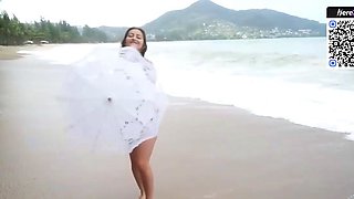 Brown haired doll in a bikini on the beach