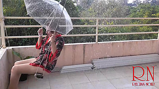 Cute lady is swinging on a hanging swing, hiding from the rain under an umbrella. 185 2