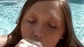 A horny brunette by the pool is sucking off his small cock