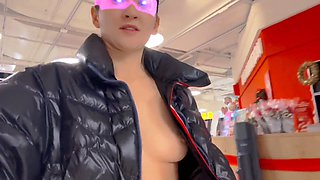 Strolling through the grocery store in a shiny puffer coat with bare breasts