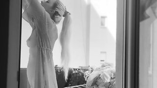 Naked chubby woman hangs out laundry on the balcony for