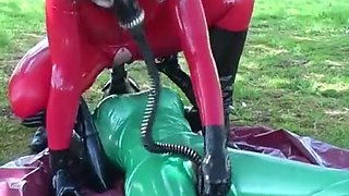 Latex lesbians in a gas mask outdoors
